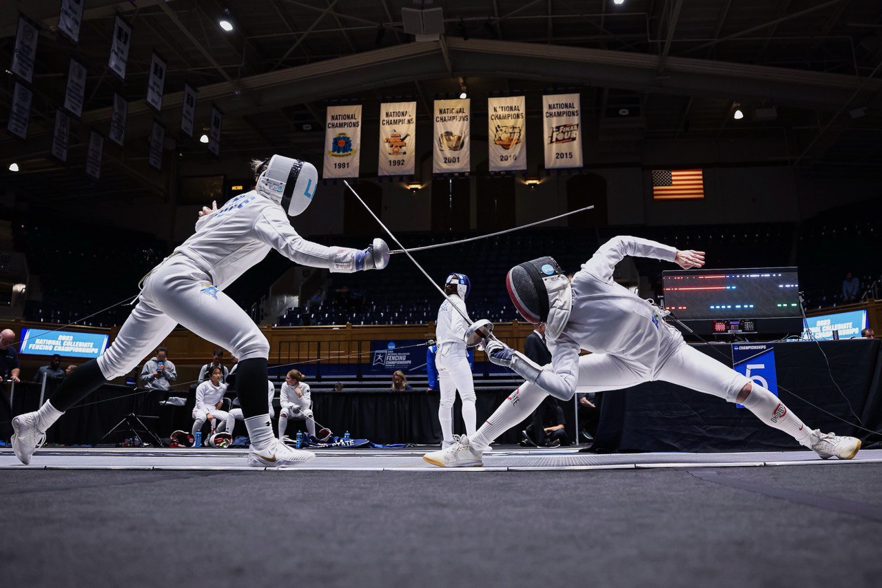 Elite competitive fencing match with two athletes in action at a national championship venue